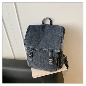 Primer plano de mochila de mezclilla lavada vintage con correas de hebilla doble