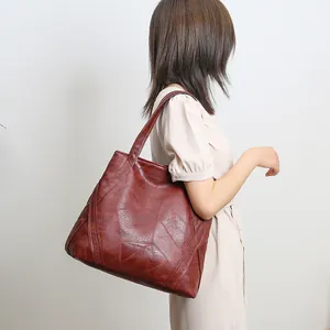 Detail of red-brown washed faux leather tote with unique geometric patchwork stitching