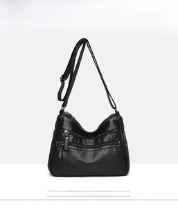 Front view of black multi-zippered crossbody bag for women with detailed faux leather texture