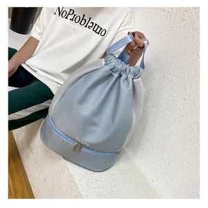 Detail of light blue gym bag with bottom shoe compartment and drawstring closure