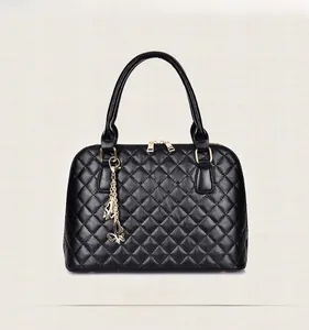 Close-up of black quilted tote bag featuring golden hardware and butterfly charm