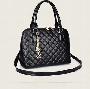 Side view of black quilted leather handbag with gold butterfly pendant and dual zippers