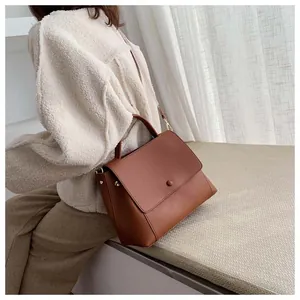 Brown leather crossbody bag shown on model with cozy cream sweater for autumn style