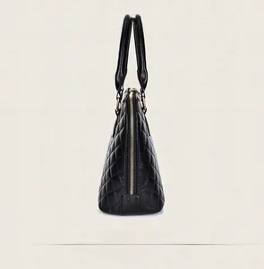 Side view of large black quilted dome bag with gold zipper and textured leather finish