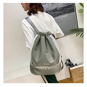 Detail view of the gray-green drawstring gym bag with mesh panels and bottom shoe compartment