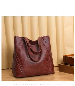Detail view of large brown washed leather tote bag with elegant stitching and soft texture
