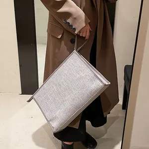 Close-up of a grey canvas business bag with top handle and refined fabric texture