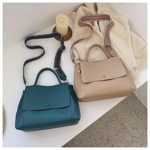 Detail of trendy handbags with geometric woven wide straps in olive green and beige colors