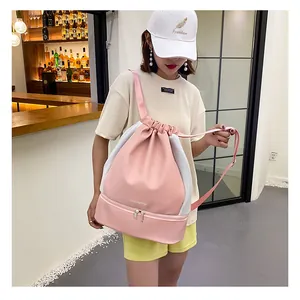 Pink drawstring gym bag with side mesh panels and bottom shoe compartment on a model