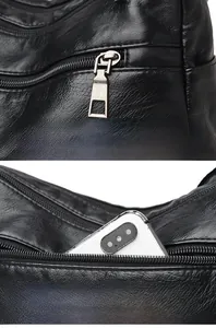 Detail of silver hardware zipper pull and rear pocket on black lychee leather shoulder bag