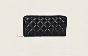 Macro shot of black quilted long zipper wallet with classic diamond pattern and gold hardware