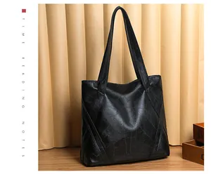 Detail of black tote bag with geometric stitching on soft leather and long strap
