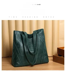 Detail of dark green leather tote bag featuring geometric stitching and shoulder strap