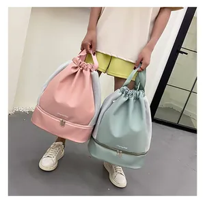 Detail of drawstring fitness bag with separate shoe compartment in pink and mint green