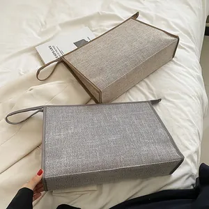 Detailed view of grey and beige canvas briefcases with zipper and carry handles