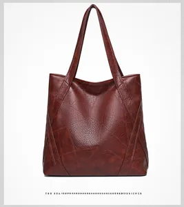 Detail of burgundy large tote bag showing soft synthetic leather and geometric stitching