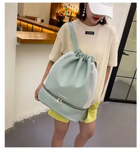 Detail of mint green drawstring gym bag featuring mesh panels and separate bottom compartment