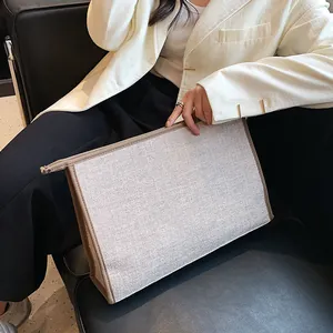 Minimalist canvas business briefcase with brown leather trim held by a model