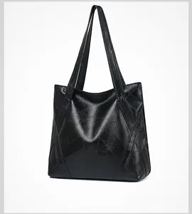Side view of black washed faux leather tote bag showing vintage cracked texture and stitching