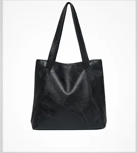 Rear view of black washed leather tote bag showing geometric stitching and soft texture