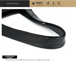 Macro detail of the ergonomic leather handle and dual stitching on a black handbag