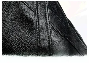 Detailed close-up showing precision parallel stitching on black lychee grain leather bag