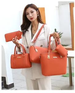 Detail of four-piece orange lychee texture handbag set with elegant gold hardware