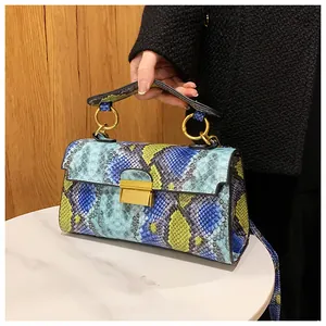 Detailed shot of vibrant snakeskin pattern on bag with gold circular metal handle