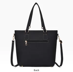 Back view of black leather tote bag with gold zipper pocket and white stitching detail