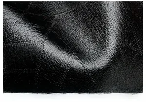 Close-up of black washed PU leather with litchi texture and high-quality stitching detail
