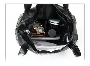 Detailed interior of black large handbag showing three compartments for easy storage