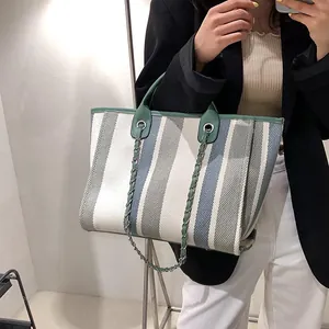 Striped canvas tote bag with chain strap and green leather handles for women