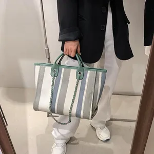 Striped large capacity bucket tote bag with green handles and silver chain detail