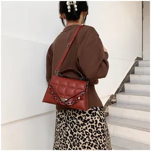 Quilted diamond lattice handbag in dark red leather shown on shoulder by female model