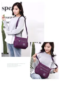 Purple nylon crossbody bag with multi-layer zipper pockets and adjustable strap