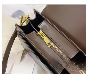 Detail view of smooth metal zipper and internal compartments of the dark brown leather bag