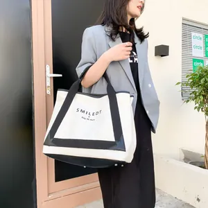 Gros plan du sac fourre-tout en toile avec renfort en cuir noir et pieds de protection