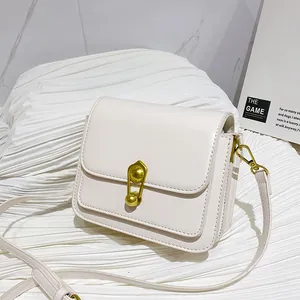 Minimalist cream white square crossbody bag with decorative golden safety pin lock