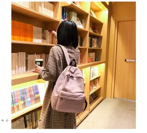 Detalle de mochila minimalista rosa claro con bolsillo con cremallera en biblioteca