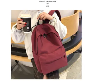 Detalle de mochila de lona burdeos con bolsillo frontal con cremallera en estilo de vida