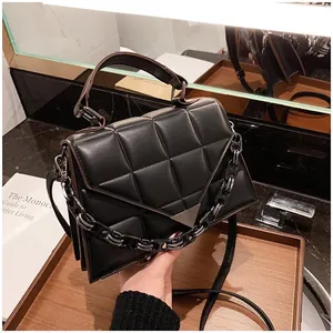 Detailed close-up of a black quilted crossbody bag with V-flap and silver metal buckle