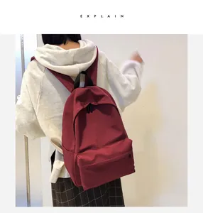 Vista posterior detallada de una mochila de lona burdeos con diseño minimalista y moderno