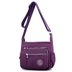 Waterproof purple nylon crossbody bag with multiple zippers and adjustable strap