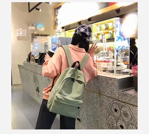 Detalle de estilo de vida de mochila de lona verde Morandi con correas ajustables y bolsillo frontal