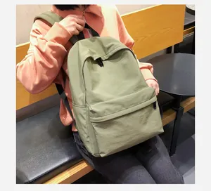 Mochila minimalista verde en una cafetería, con gran capacidad y tela de nailon suave