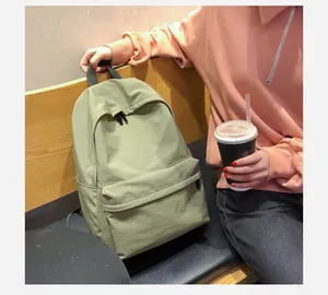 Primer plano de una mochila minimalista de nailon verde en un ambiente de café