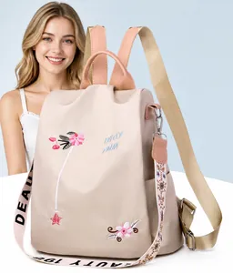Close-up of floral embroidery and stylish colorful strap on beige backpack