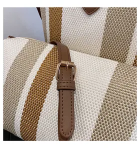 Κοντινό πλάνο ριγέ τσάντας canvas με δερμάτινο λουράκι και χρυσή μεταλλική αγκράφα