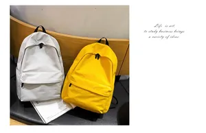 Mochilas de lona minimalistas en beige y amarillo sobre un banco de madera en entorno de estilo