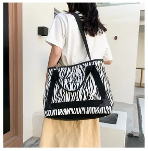 Sac fourre-tout en toile à rayures zèbre porté par un mannequin, vue de dos
